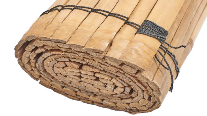 Natte en bambou enroulée et maintenue par une corde noire